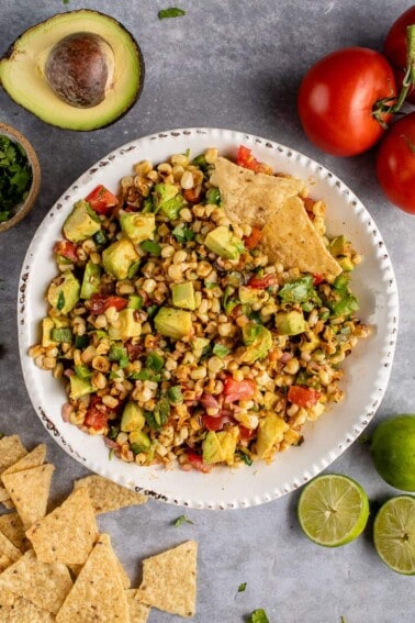 vertical photo of Avocado and Roasted Corn Salad in white bowl
