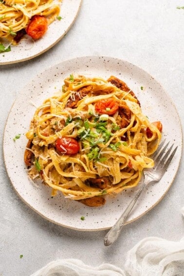 macro image of Cajun-Style Fettuccine Alfredo with Blackened Vegan Chicken on a plate with fork