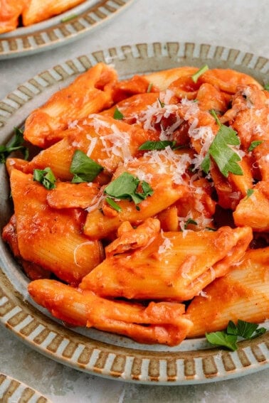 close up photo of creamy vegan cajun pasta on light blue plate