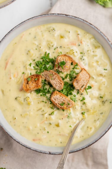 Vegan Broccoli Cheddar Soup in a bowl with croutons and parsley