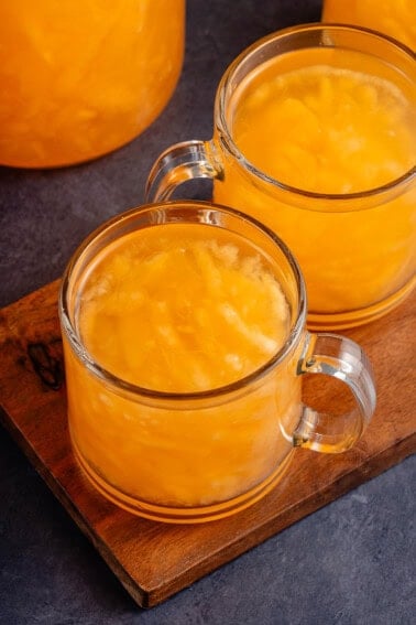 two glasses of melon juice on a brown board