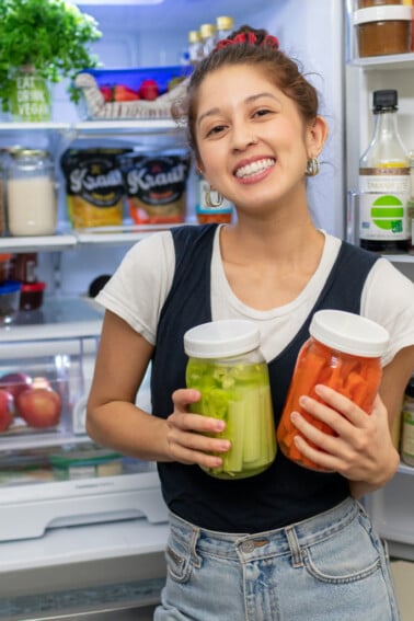 Standing in front of the open fridge with vegetables. Sweet Simple vegan fridge