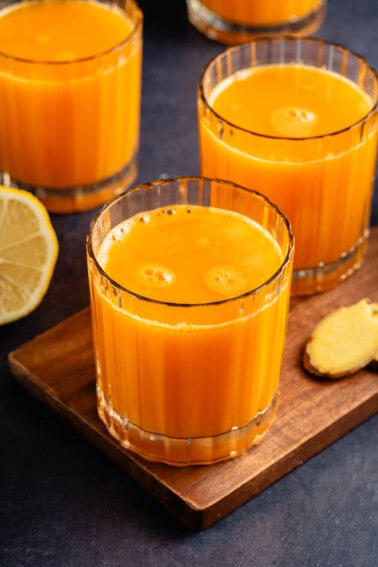 glass cups of antioxidant rich immunity juice on blue table