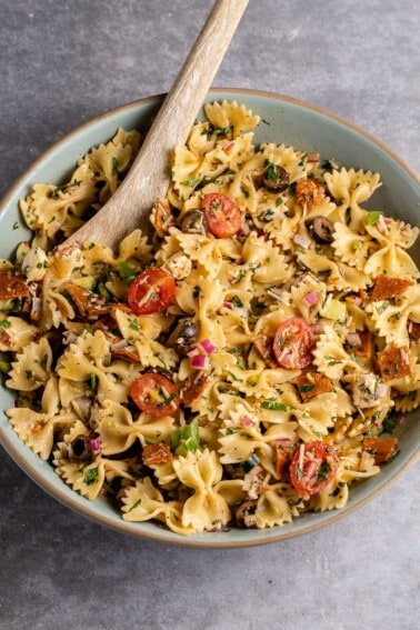 vertical photo of Italian-Inspired Pasta Salad in blue bowl