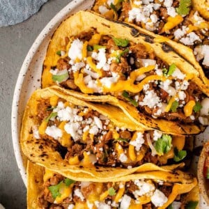 overhead image of lentil walnut tacos loaded with fixings on white speckled plate