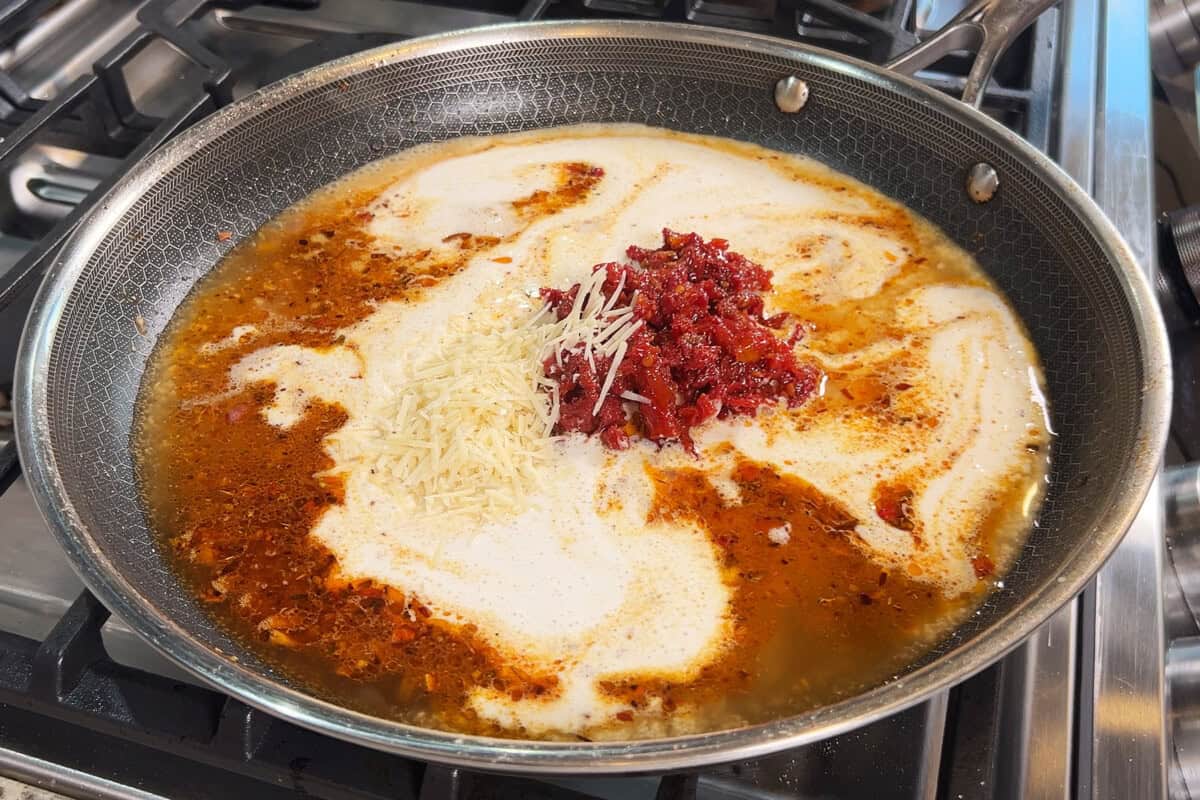 adding parm and sun dried tomatoes to skillet