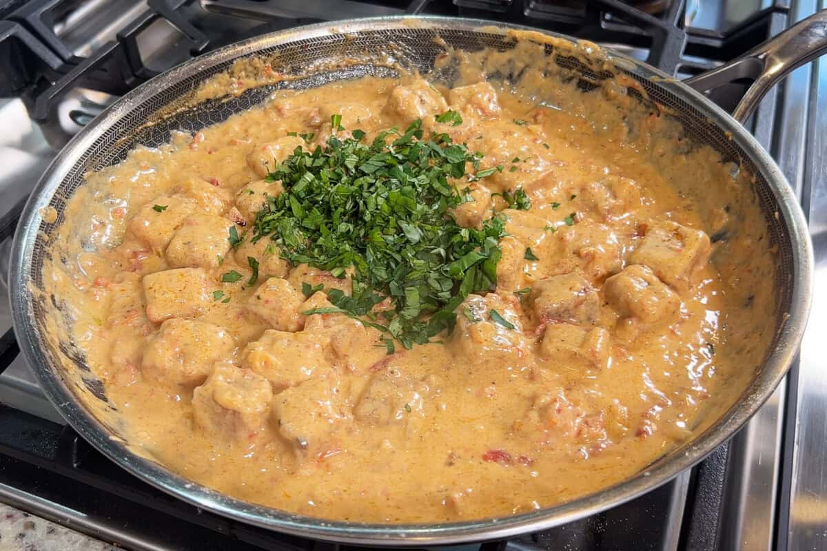 adding freshly sliced basil and parsley to marry me tofu