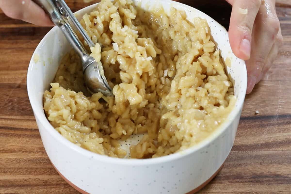 scooping risotto out of bowl