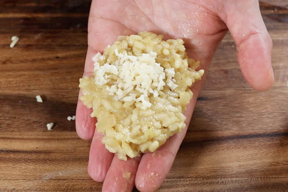 adding cheese to flattened rice patty