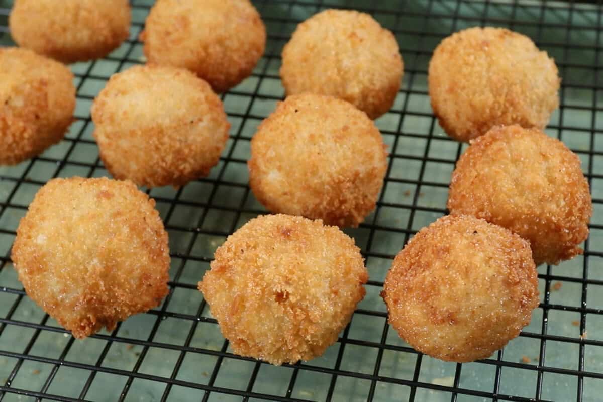 fried arancini cooling on a wire rack