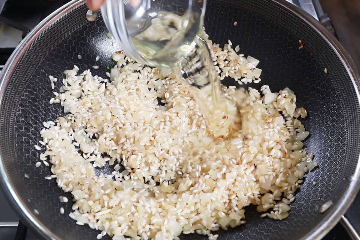 adding white wine to rice mixture