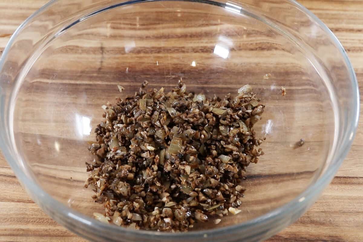 adding the cooked mushrooms, onions, and garlic to a bowl