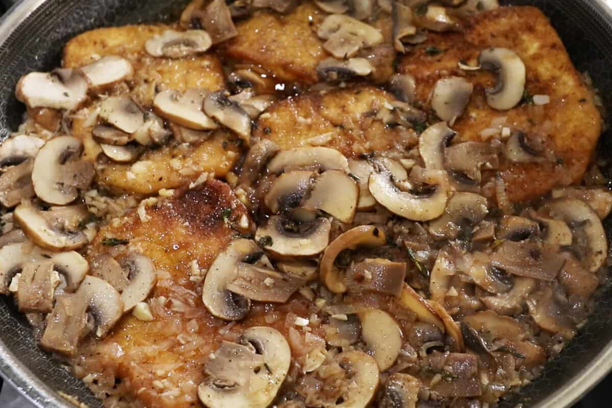 tofu simmering in pan with mushrooms