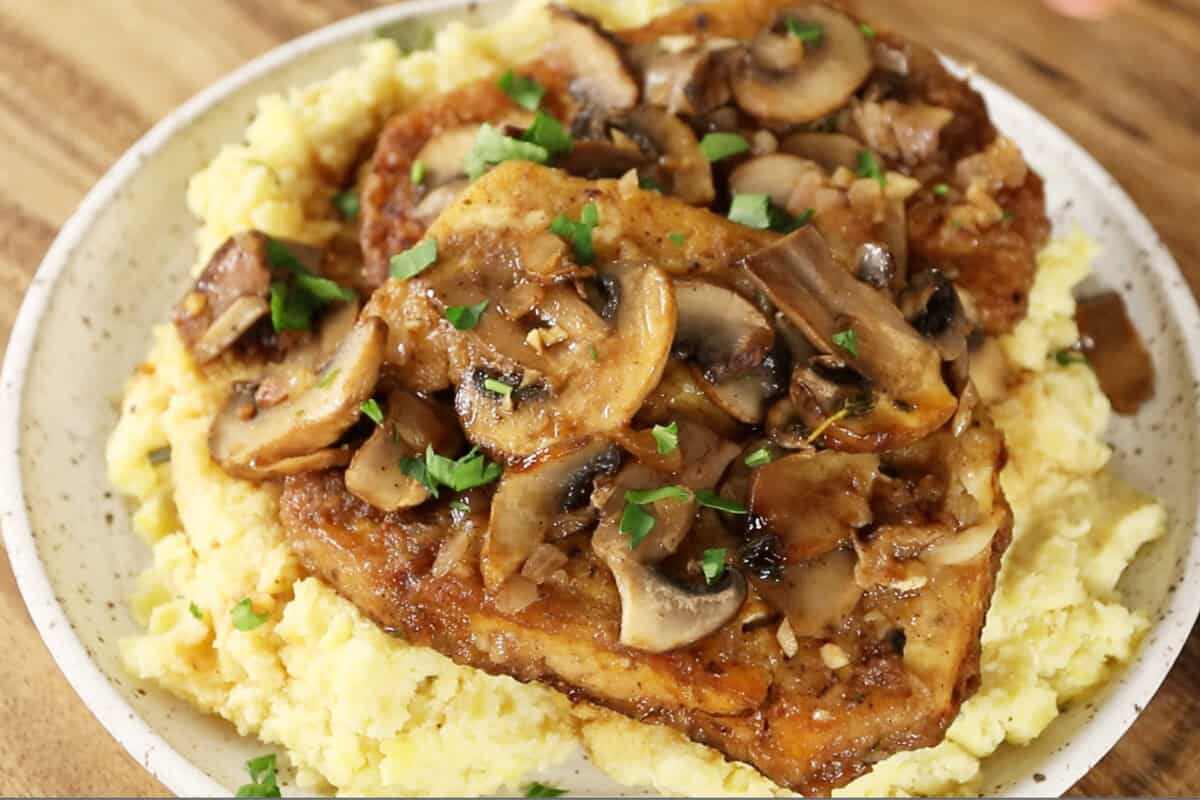 Plate of marsala tofu served over a bed of mashed potatoes