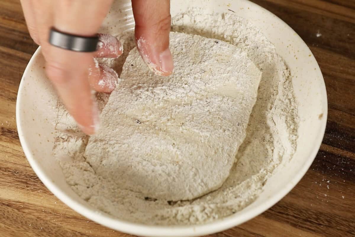 dredging tofu in seasoned flour mixture