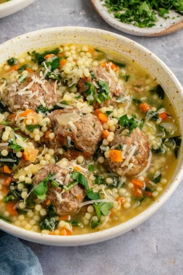 bowl of vegan italian wedding soup topped with parmesan