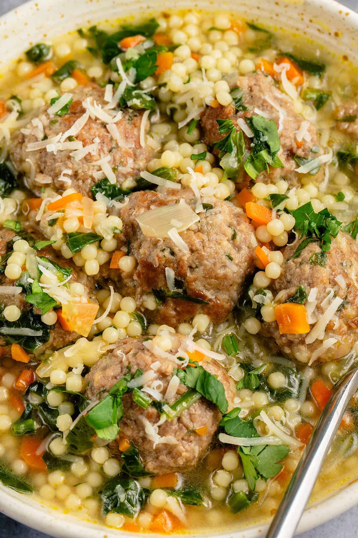 close up of bowl of vegan italian wedding soup topped with parmesan