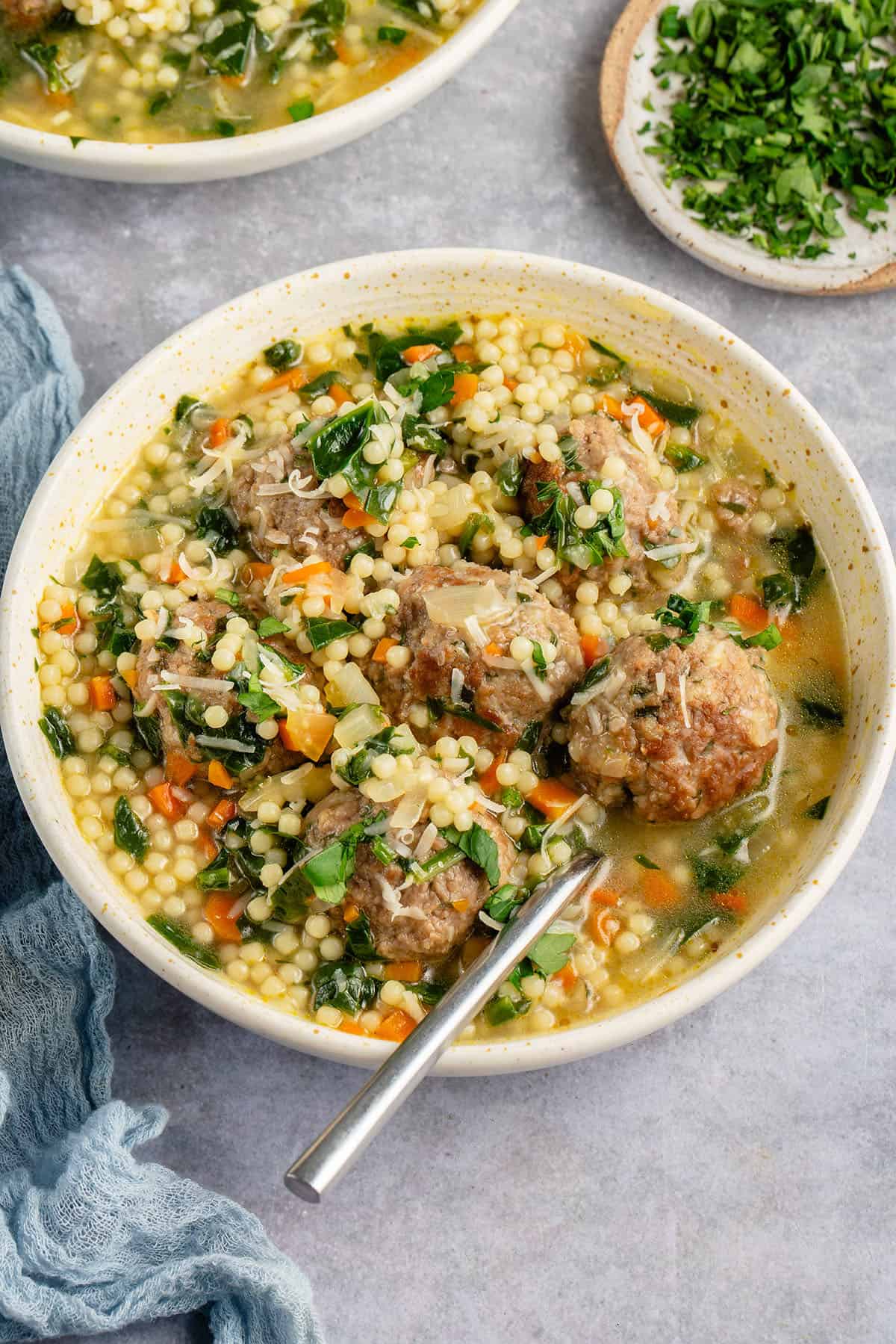 bowl of vegan italian wedding soup topped with parmesan