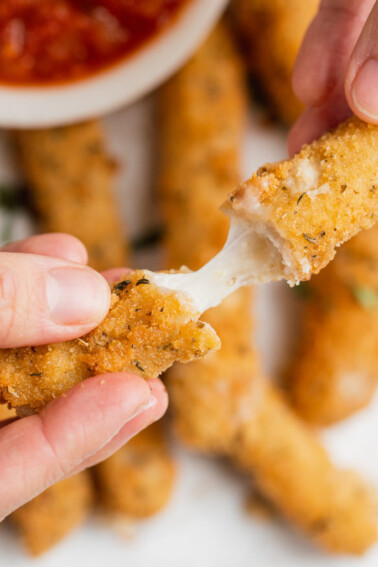 Stretchy cheese in a mozzarella stick with marinara sauce