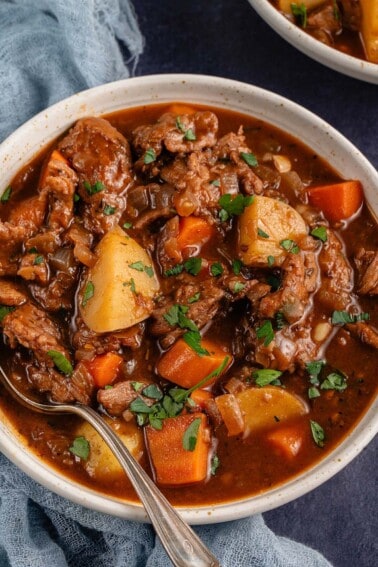 close up photo of a bowl of vegan beef stew with spoon