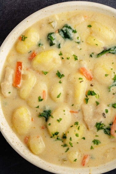 overhead close up of Vegan Chicken Gnocchi Soup (Olive Garden Copycat) in beige bowl