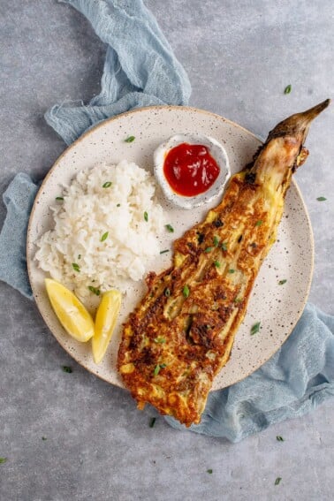 white plate with vegan tortang talong, rice and banana ketchup